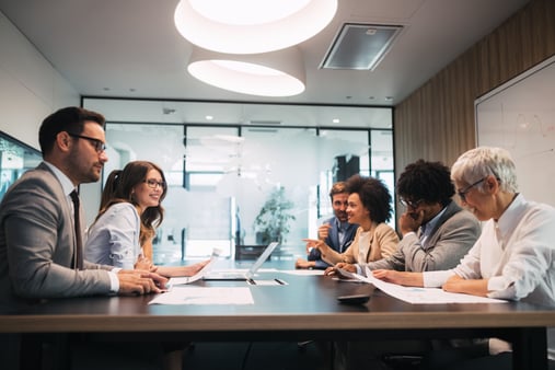 Group of business people discussing business plan at meeting in modern office.