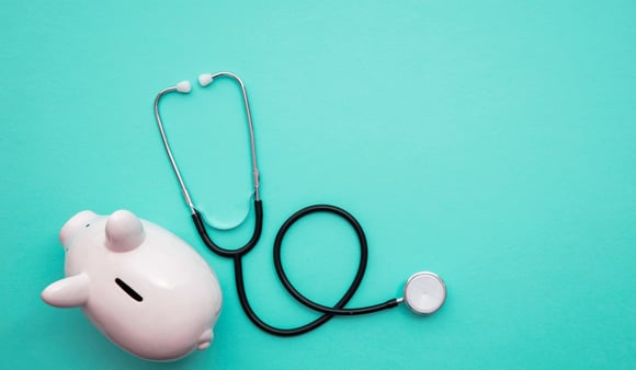 Concept of the ACA. A piggy bank next to a doctor's stethoscope. 