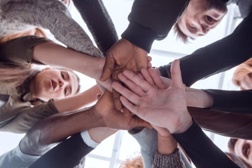 Low angle view of diverse businesspeople stacking hands in circle at office