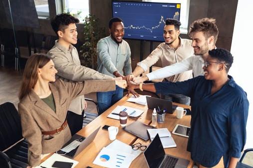 Multiethnic group of business people shaking hands, finishing up a meeting.