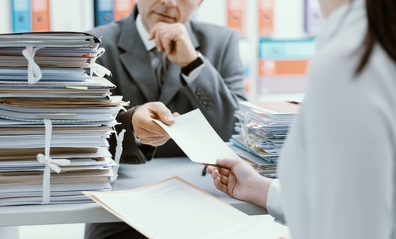 Two employees reviewing paperwork and benefits forms 