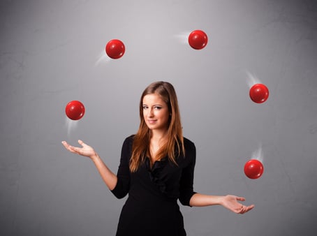 Young woman juggling red balls 