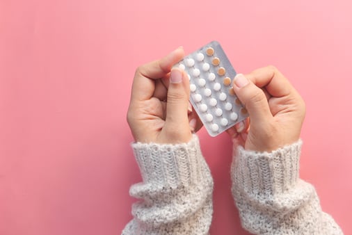 Woman holding a packet of birth control pills 