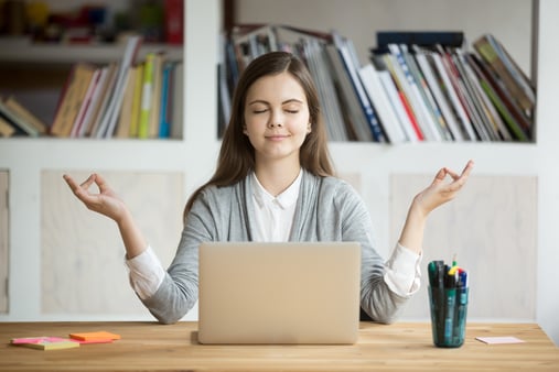 A woman sitting at her desk, meditating