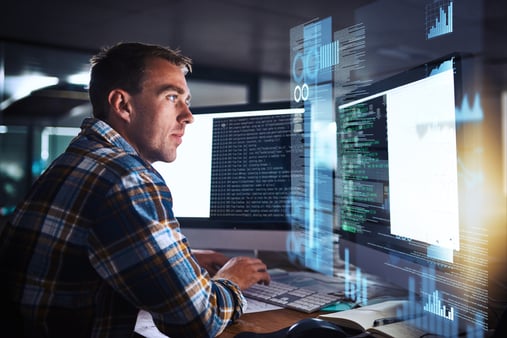Concept of cybersecurity. A man sitting at his computer making it secure. 