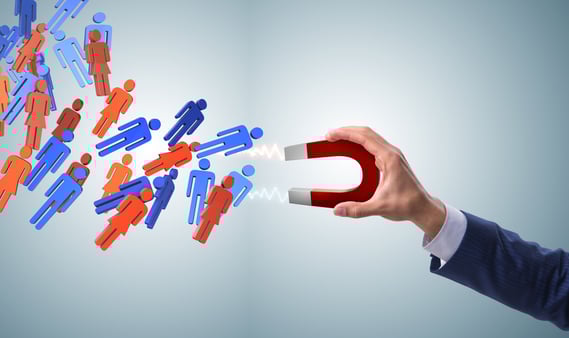 A hand holding a magnet and attracting people 