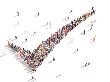 Image of people standing in a checkmark pattern