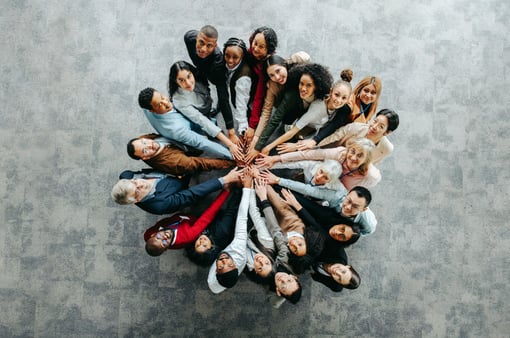 The concept of diversity, equity, and inclusion. A diverse team with hands all-in. 