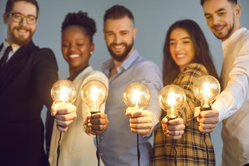 A team holding up lightbulbs. Concept of a good idea. 