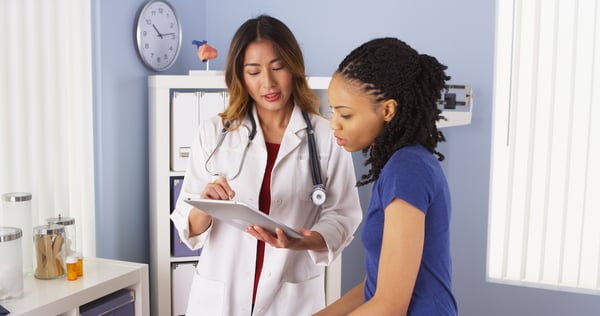 A doctor showing a patient information on a tablet