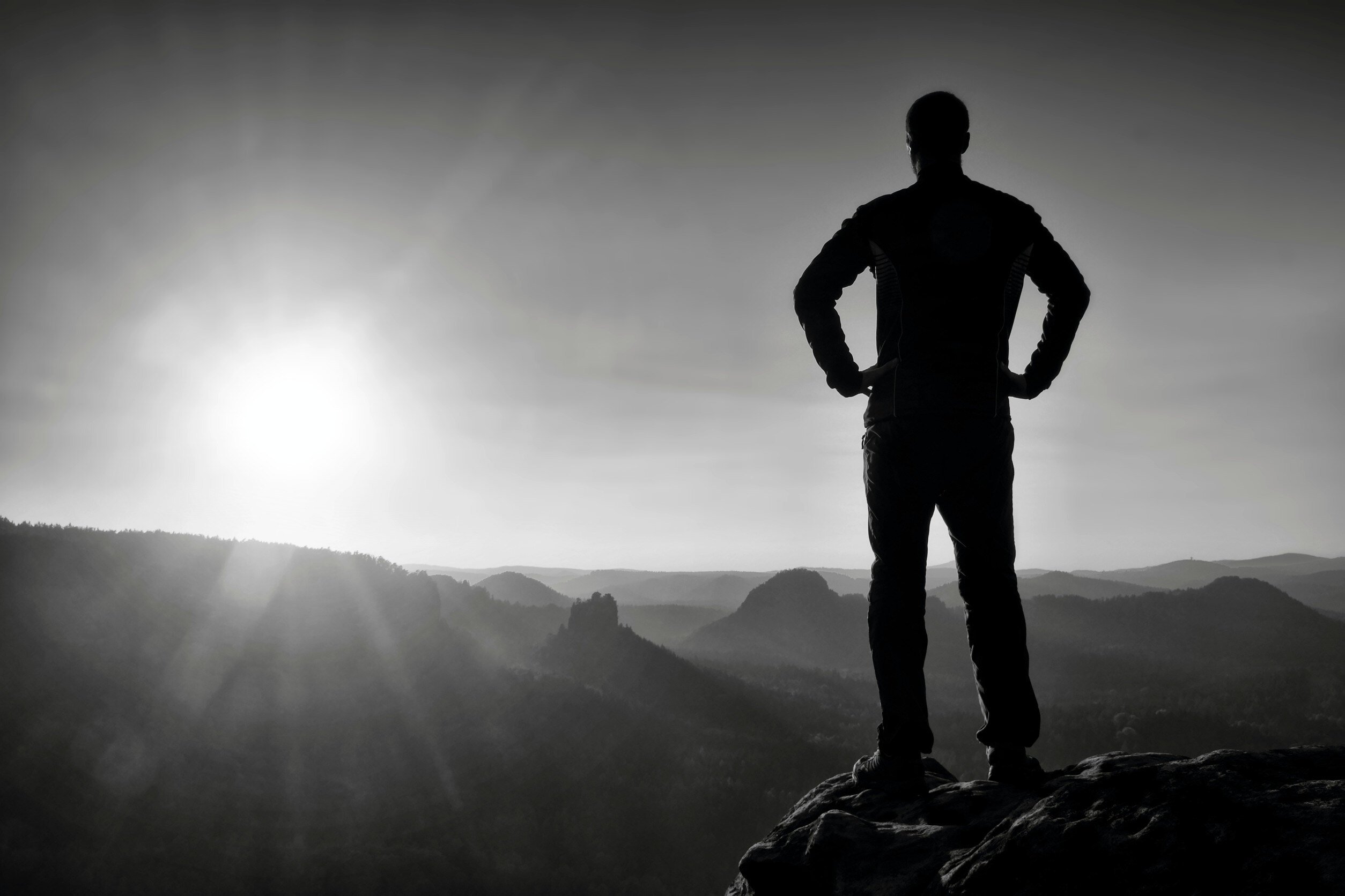 Person standing at the top of a summit with hands on hips, the concept of confidence