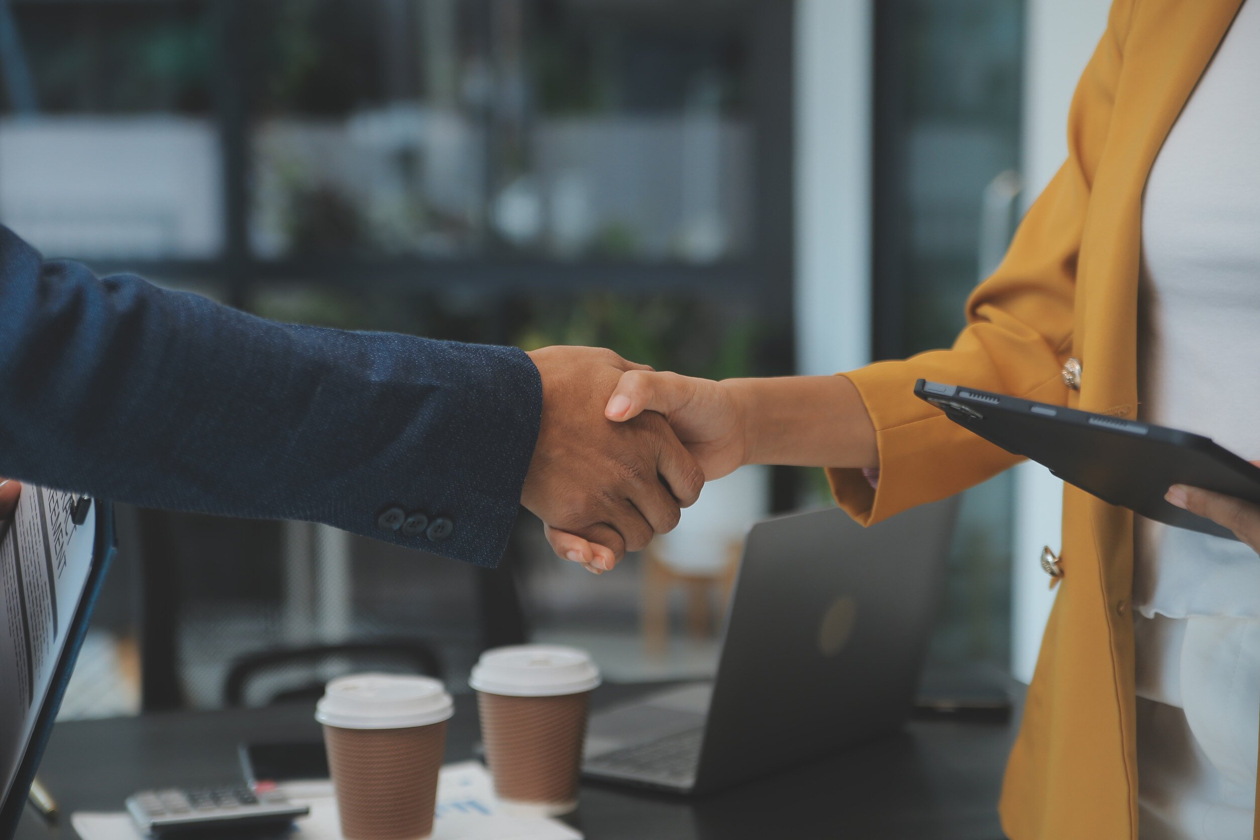 A sales and service team member shaking hands and working together